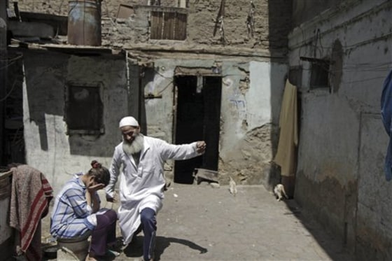 A man jokes with a woman outside their house in Boulaq Abu El-Ela in downtown Cairo, Egypt. Eight families, at least 70 people, share the eight-room mud brick dwelling.